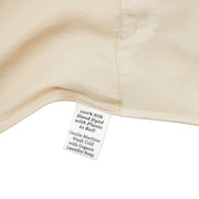 Close-up of a silk in vanilla with a label detailing care instructions