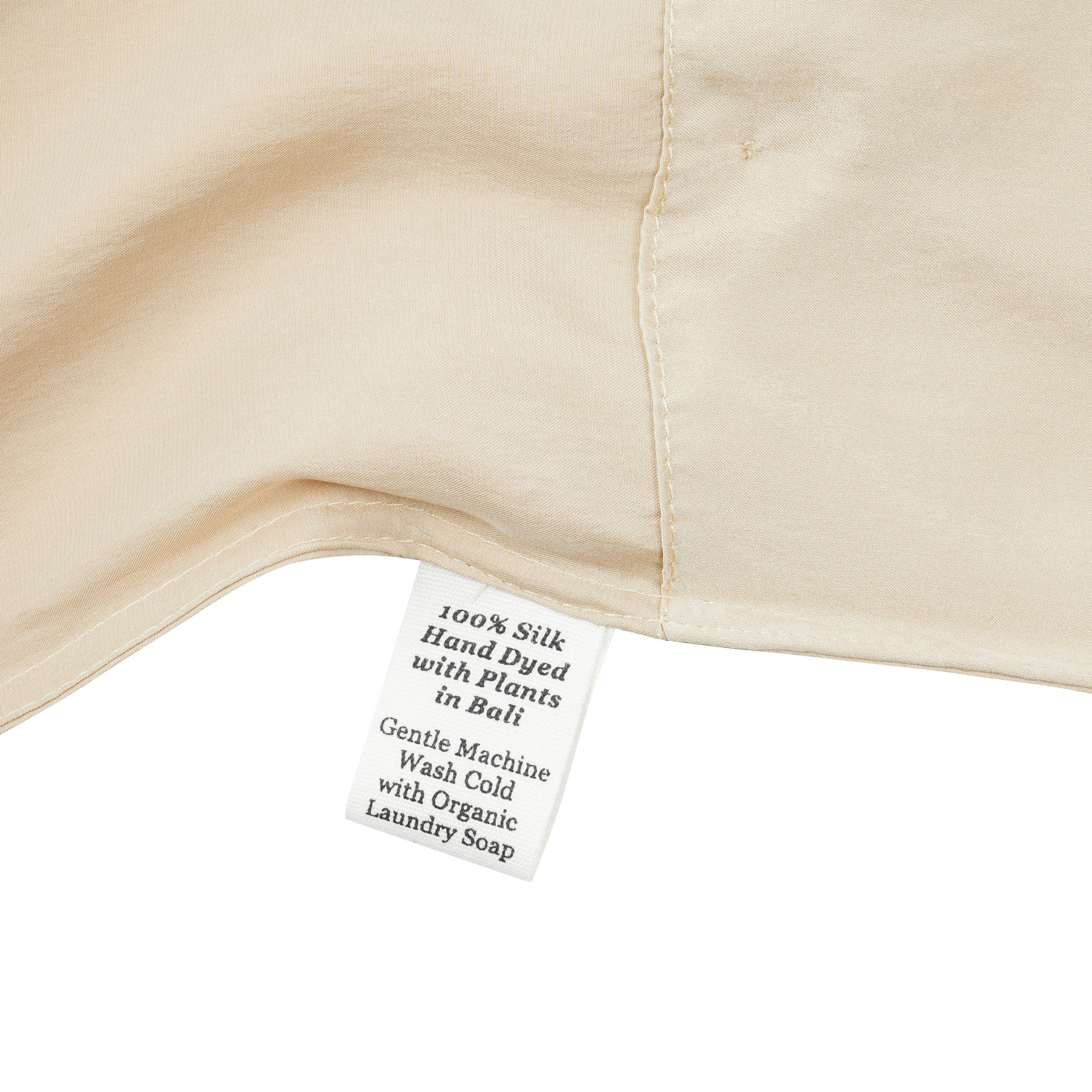 Close-up of a silk in vanilla with a label detailing care instructions